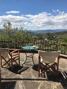 two chairs and a table on a patio with a view at Chariklia Traditional House in Papigko