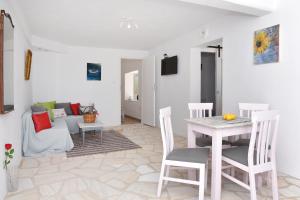 ein Wohnzimmer mit einem Tisch, Stühlen und einem Sofa in der Unterkunft VILLA PETROS SEA SUITE in Megas Gialos - Nites