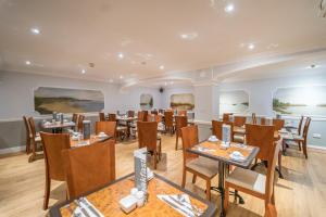 a restaurant with tables and chairs in a room at Atlantic Hotel in Tenby