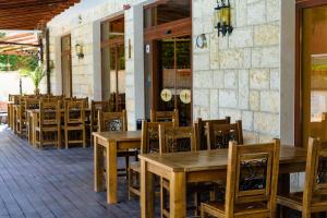 a restaurant with wooden tables and chairs on a patio at Villa Maria Revas in Sunny Beach