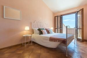 a bedroom with a bed and a large window at Villa Bellavista con piscina privata, vista mare vicino a Villasimius in Villasimius
