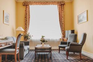 a living room with chairs and a table and a window at Hotel Spöttel in Bad Nauheim