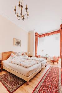 two beds in a bedroom with a chandelier at Hotel Spöttel in Bad Nauheim