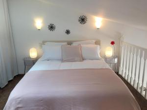 a bedroom with a white bed with two lamps at Gîtes de La Condamine in Curbans +41 photos