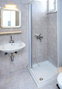 a bathroom with a shower and a sink at Fotini Studios in Kámpos +10 photos