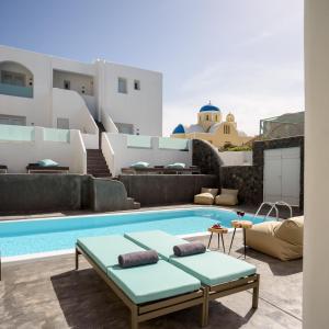 
a living room filled with furniture and a pool at Elitoz Suites in Oia
