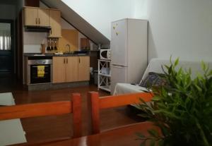 a small kitchen with a white refrigerator and a couch at El Charquito in Famara