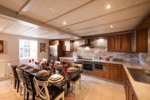 cocina grande con mesa larga y sillas en Thornhill House - Historic 5 Bedroom 5 Ensuite, en Stirling