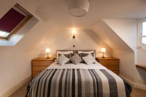 una camera con un letto con due comodini e due lampade di Thornhill House - Historic 5 Bedroom 5 Ensuite a Stirling