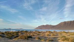 a beach with a mountain in the background at El Charquito in Famara
