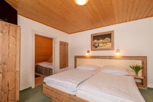 a bedroom with a large bed with a wooden ceiling at Haslehnerhof in Ramsau am Dachstein