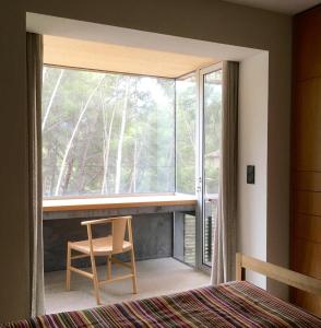 ein Schlafzimmer mit einem Fenster und einem Stuhl neben einem Bett in der Unterkunft Villa Magali in Sanary-sur-Mer