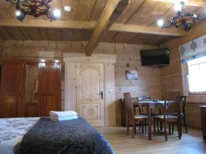 1 dormitorio con 1 cama y comedor con mesa en BoBak noclegi, en Chochołów
