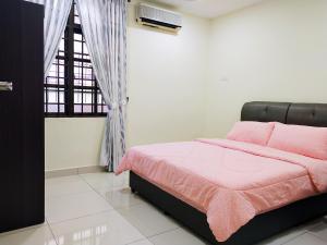 een slaapkamer met een roze bed en een raam bij Ipoh TG Signature in Ipoh