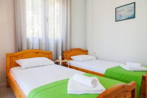 two twin beds in a room with a window at Agapanthus house in Lefkada