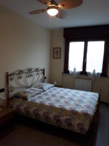 Schlafzimmer mit einem Bett und einem Deckenventilator in der Unterkunft Appartamento da Maria Angela in Pioltello