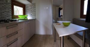 una cocina con una mesa y un tazón verde. en Camping Lacona, en Capoliveri
