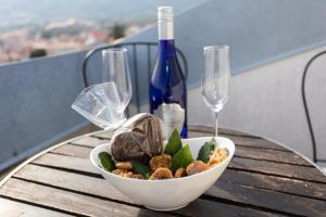 una ciotola di cibo su un tavolo con una bottiglia di vino di Apartmani Velnic a Baška Altre 13 foto