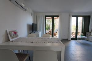 ein weißes Esszimmer mit einem Tisch und Stühlen in der Unterkunft Studio apartman - MELLITUS in Molat