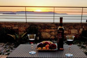 una mesa con dos copas de vino y un tazón de fruta en Sody Magnificent Bay View, en La Canea