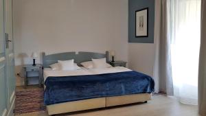 a bedroom with a large bed with a blue blanket at Ferienwohnungen Unter den Linden in Thiessow