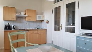 a small kitchen with a table and a television at Ferienwohnungen Unter den Linden in Thiessow +33 photos