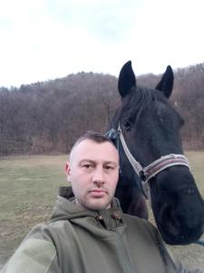 バイレ・オラネシュティにあるCasa Olanescuの馬の前に立つ男
