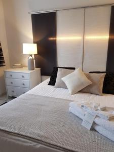 a bedroom with a bed with white sheets and a lamp at Hôtel L'ideal le Mountbatten in Arromanches-les-Bains