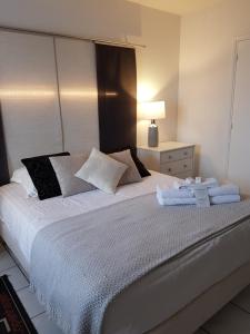 a bedroom with a large bed with towels on it at Hôtel L'ideal le Mountbatten in Arromanches-les-Bains