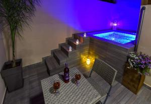 a bottle of wine sitting on a table next to a swimming pool at Aretousa Suites in Chania Town