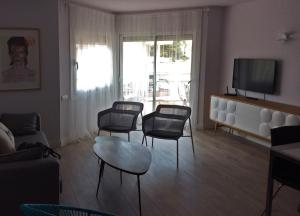 a living room with chairs and a table and a tv at A3A Baixa Mar in Torredembarra