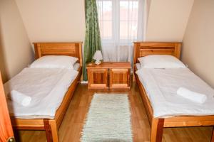 2 camas individuales en una habitación con ventana en Ambrózia Guesthouse, en Nagykanizsa