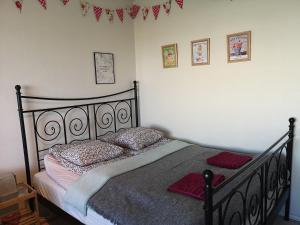 a bedroom with a black bed with pillows on it at The cupcake apartment / Kuppikakkuyksiö in Turku