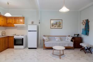 a kitchen with a couch and a refrigerator in a room at Agapanthus house in Lefkada +18 photos