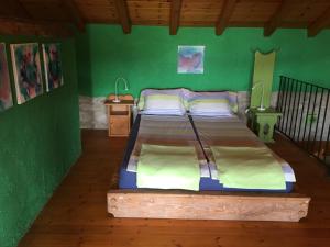a bed in a room with a green wall at Spiti Anne in Makrádes