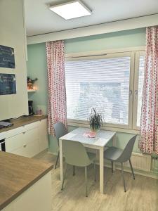 a kitchen with a table and chairs and a window at The cupcake apartment / Kuppikakkuyksiö in Turku