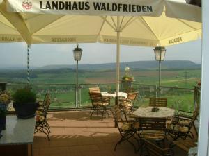 un patio con mesas y sillas en el balcón en Landhaus Waldfrieden en Tengen