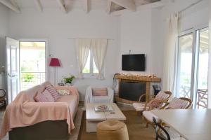 salon z kanapą i telewizorem w obiekcie Corinthian Sun - Vacation Home w mieście Korynt
