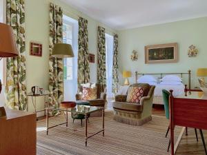 a bedroom with a bed and a couch and a table at Le Clos Saluces in Avignon