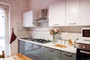a kitchen with white cabinets and a vase of flowers at La Casa di Giò in Asti