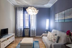 uma sala de estar com um sofá e uma televisão em La Casa di Giò em Asti