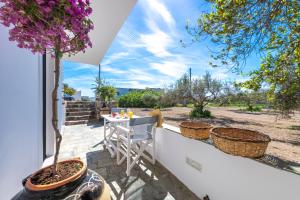 a patio with a table and a tree at Madalena's Summer House in Adamantas