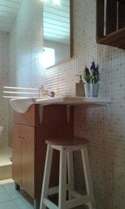 uma casa de banho com um lavatório, um banco e um espelho. em Casa Moinho do Oeste - West Windmill Portugal em Moledo