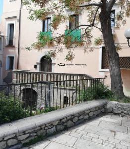 a fence in front of a building with a tree at Valerio's Home Historical Center in Larino