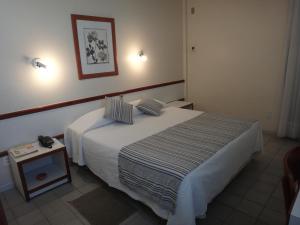 a bedroom with a large bed and a table at Hotel Jangadeiro in Aracaju