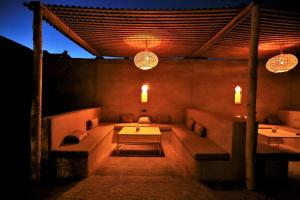 a room with couches and a table and lights at Riad Dar Ouzine in Merzouga