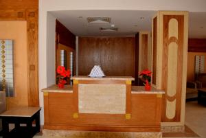 a lobby with a reception counter with red flowers at Hawaii Riviera Club Aqua Park - Families and Couples Only in Hurghada