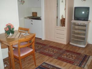 a living room with a table and a television at Vadsø Apartment in Vadsø