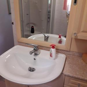 ein Badezimmer mit einem weißen Waschbecken und einem Spiegel in der Unterkunft B&B la Casa del daino in Millesimo