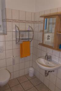 uma casa de banho com um lavatório, um WC e um espelho. em TOTO's Gasthaus em Hattingen